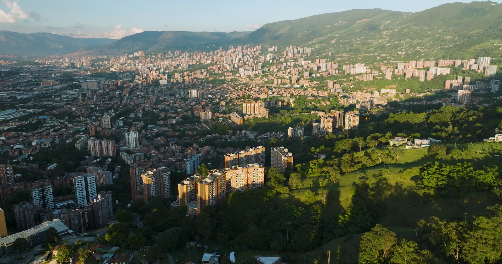 Aerial view over El Poblado, Medellín — the city and the mountains at dusk