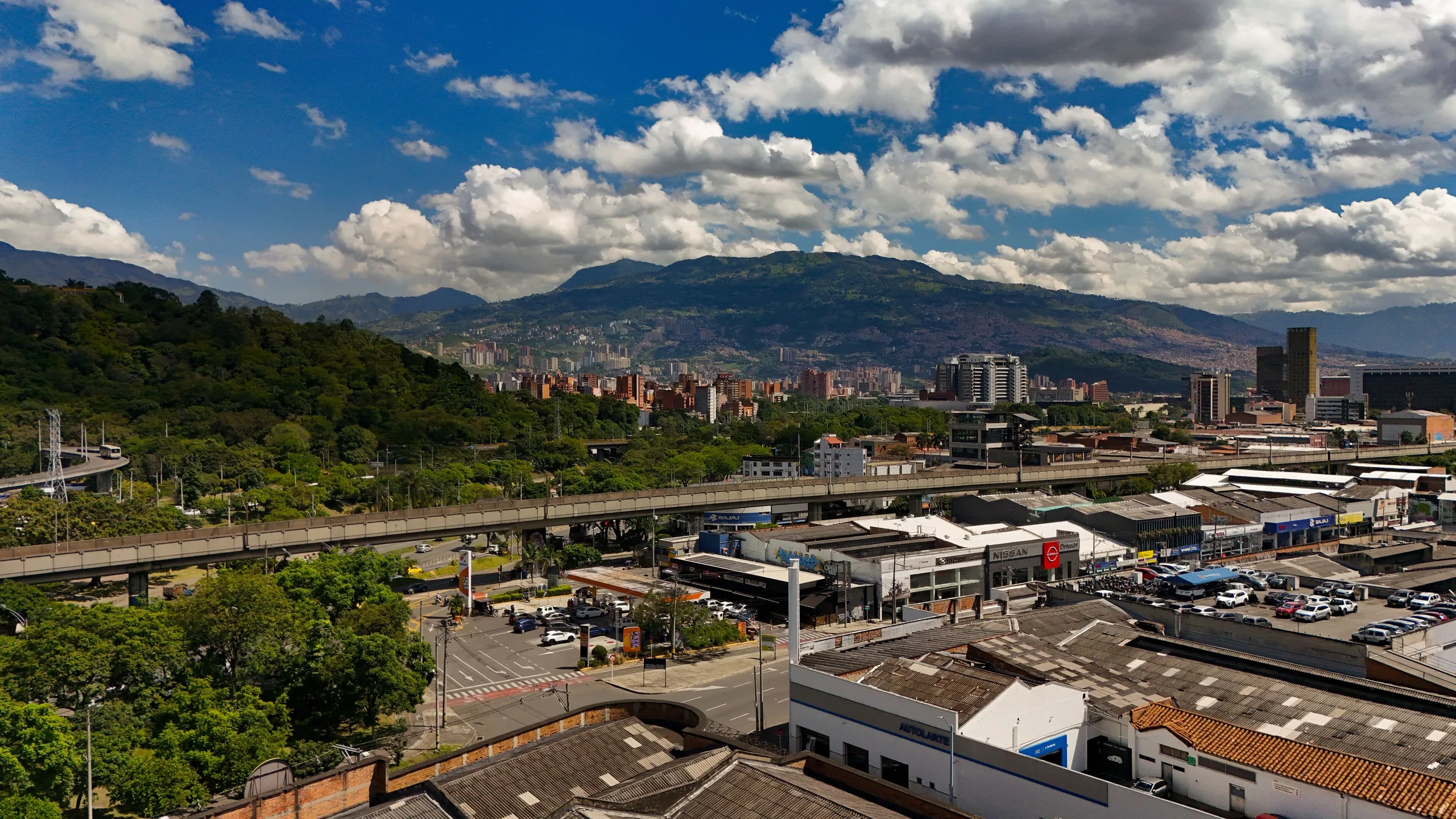 Aerial view over the Laureles–Estadio area of Medellín toward the green mountains