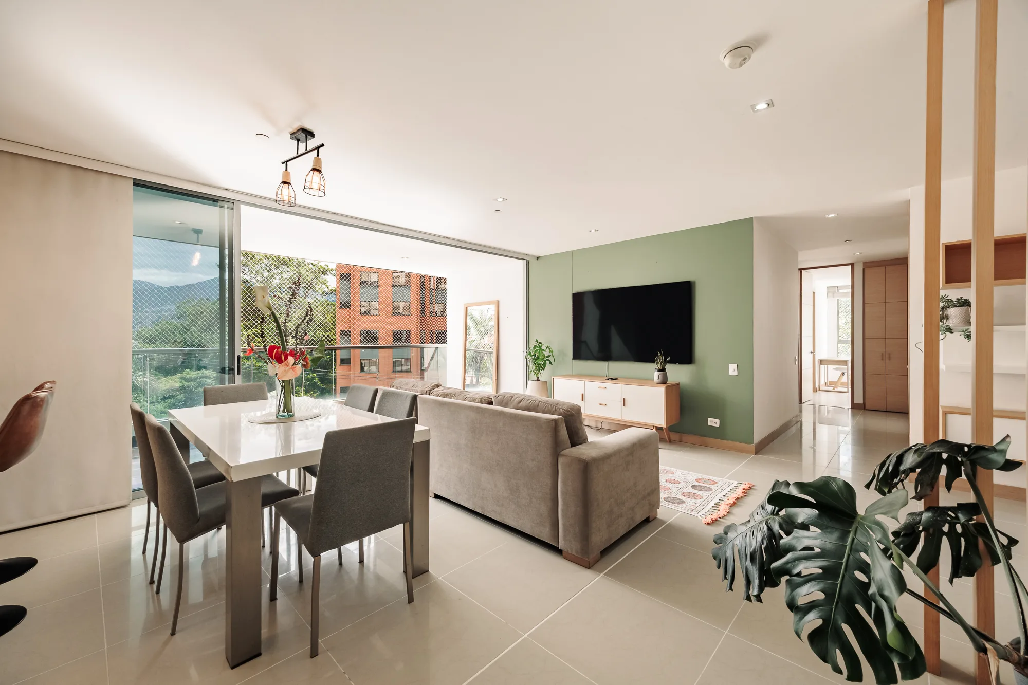Open-plan dining and living area with a table for six, opening to the balcony at Balcón Verde