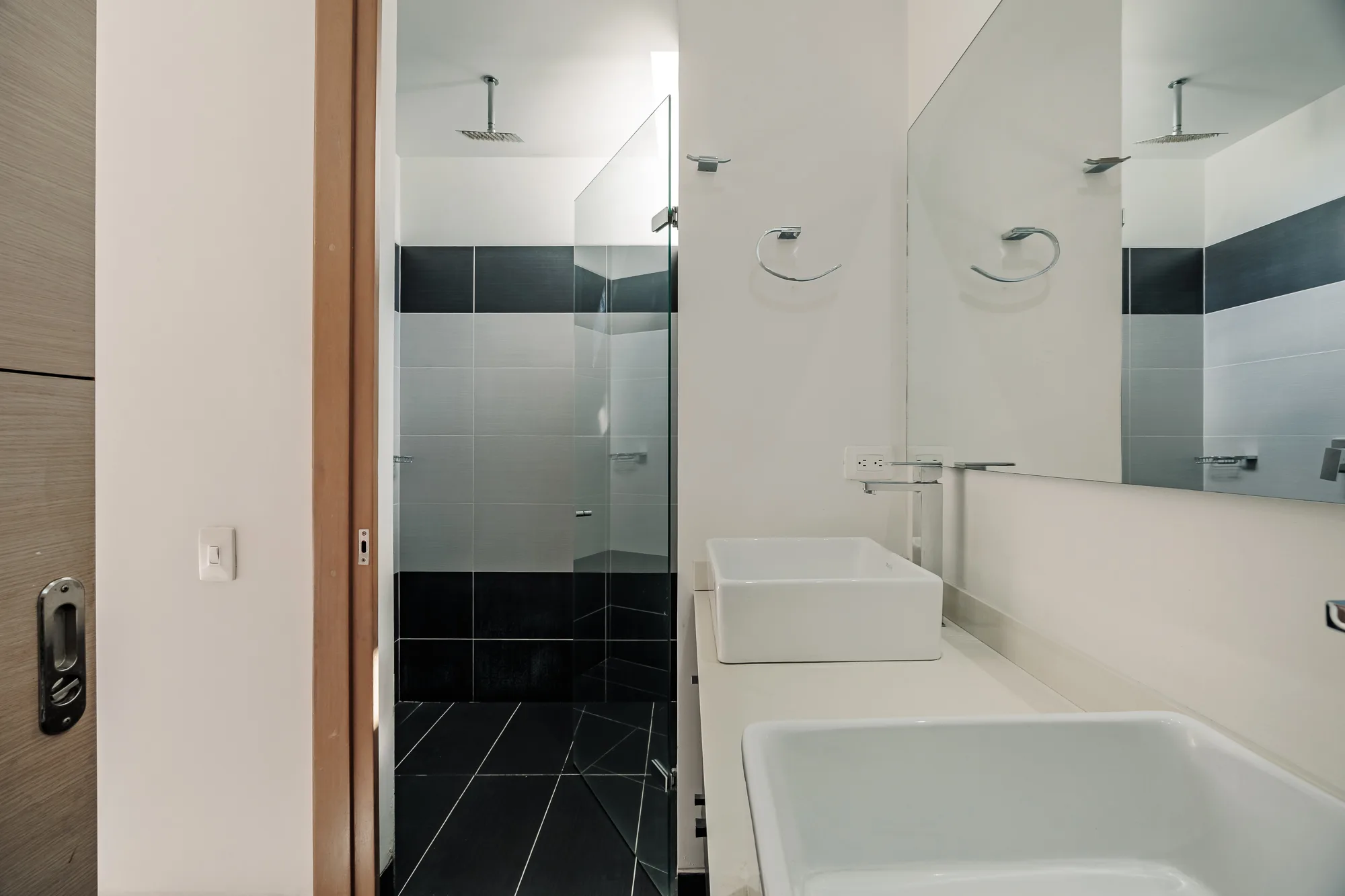 Master bathroom with a walk-in shower and dark tile at Balcón Verde