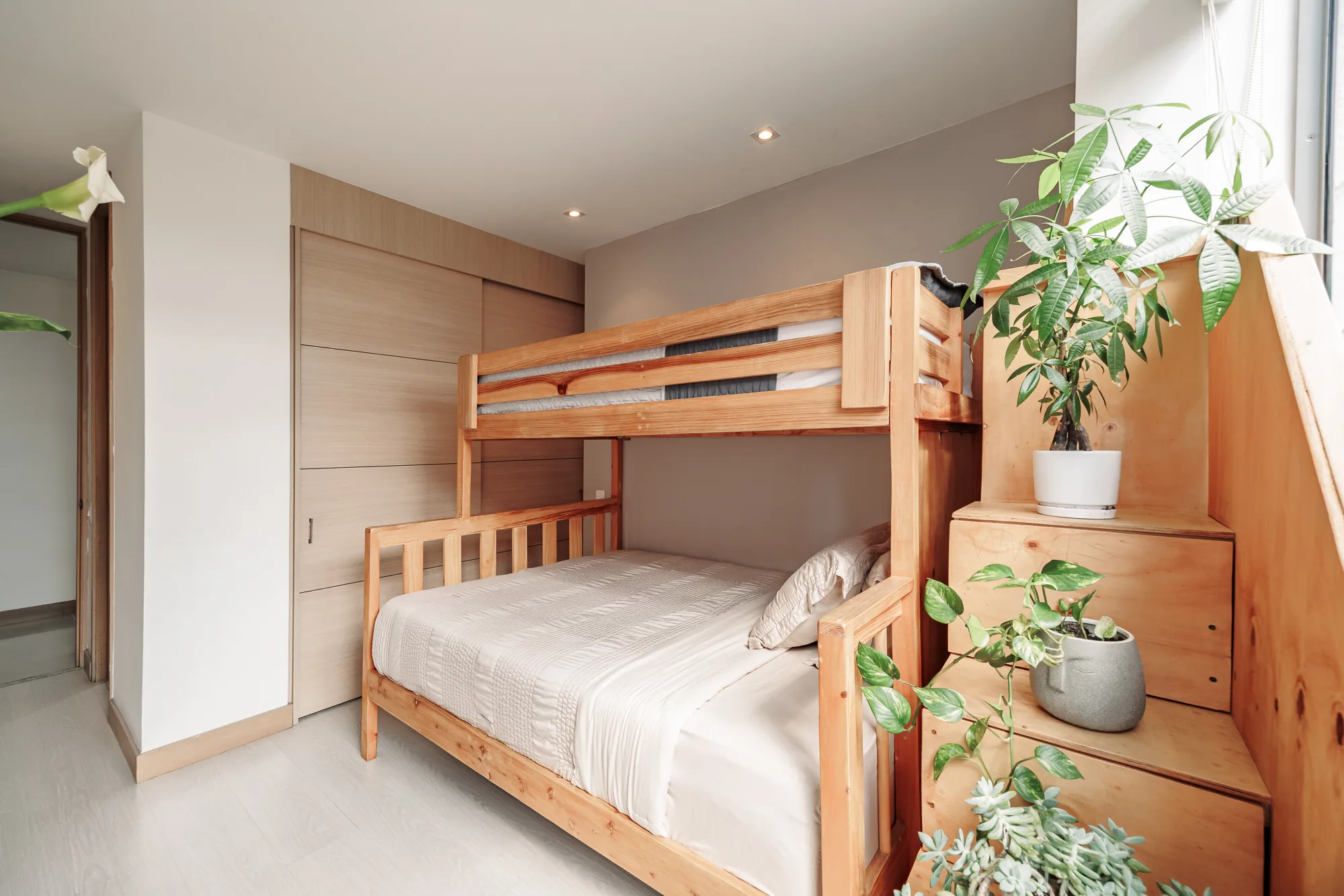 Bunk-bed room with wooden bunks, stairs and plants at Balcón Verde