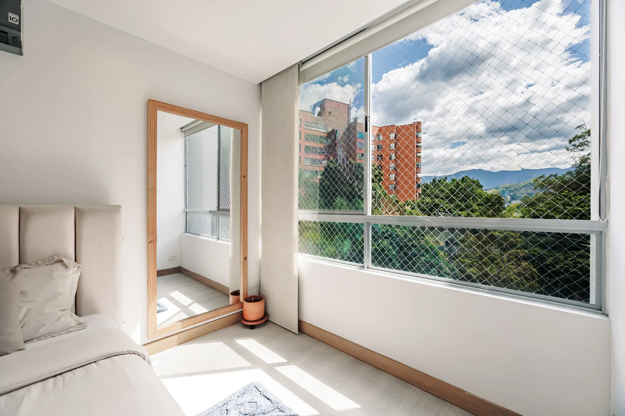 Bedroom window with a green view over the gardens at Balcón Verde, El Poblado