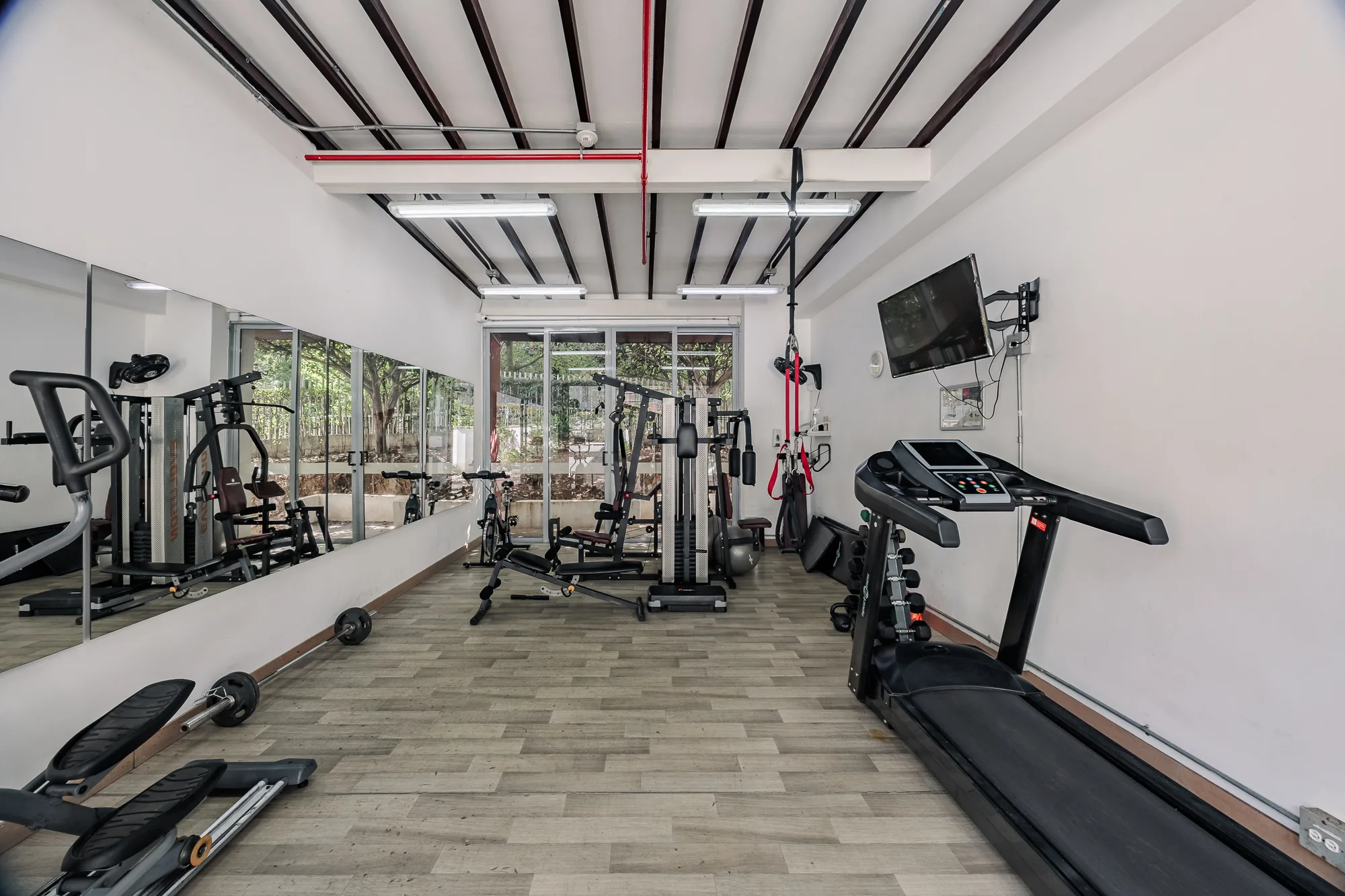 Residents' gym with cardio and weight machines in the building at Balcón Verde
