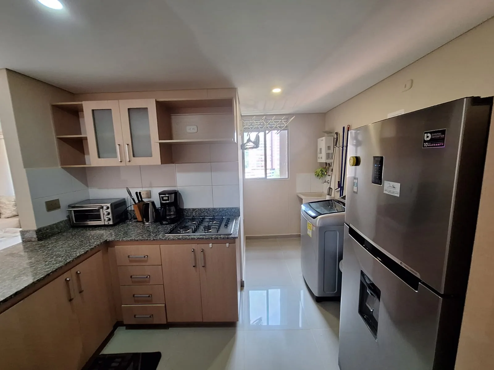 Fully-equipped kitchen with wood cabinetry and granite counters at Sabaneta Parkside