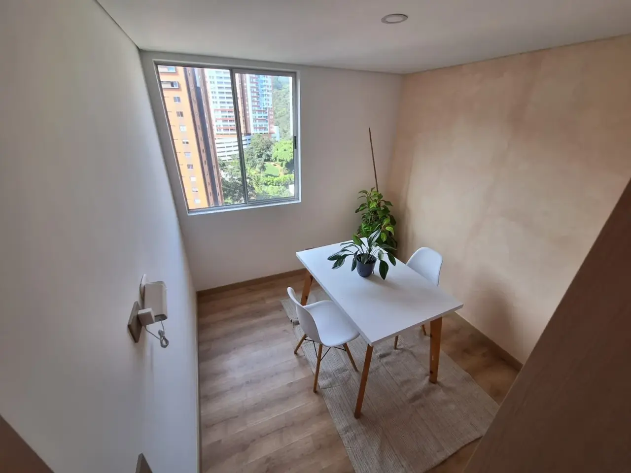 Home office with a white table, two chairs and a window at Sabaneta Parkside