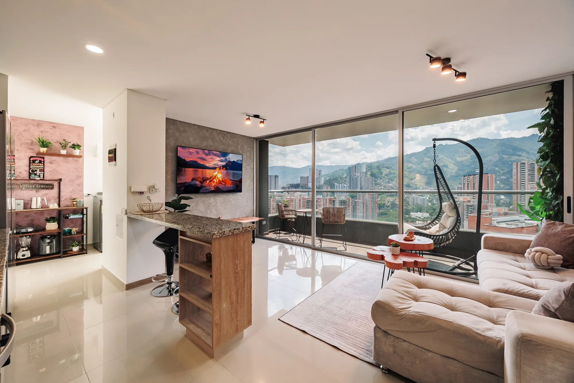 Sabaneta Skyline — the living room from the entrance: kitchen bar, TV wall and the glass wall to the balcony, 30 floors over Sabaneta