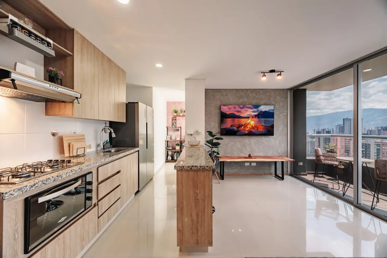 Open kitchen with a granite breakfast bar and two stools, the valley through the window
