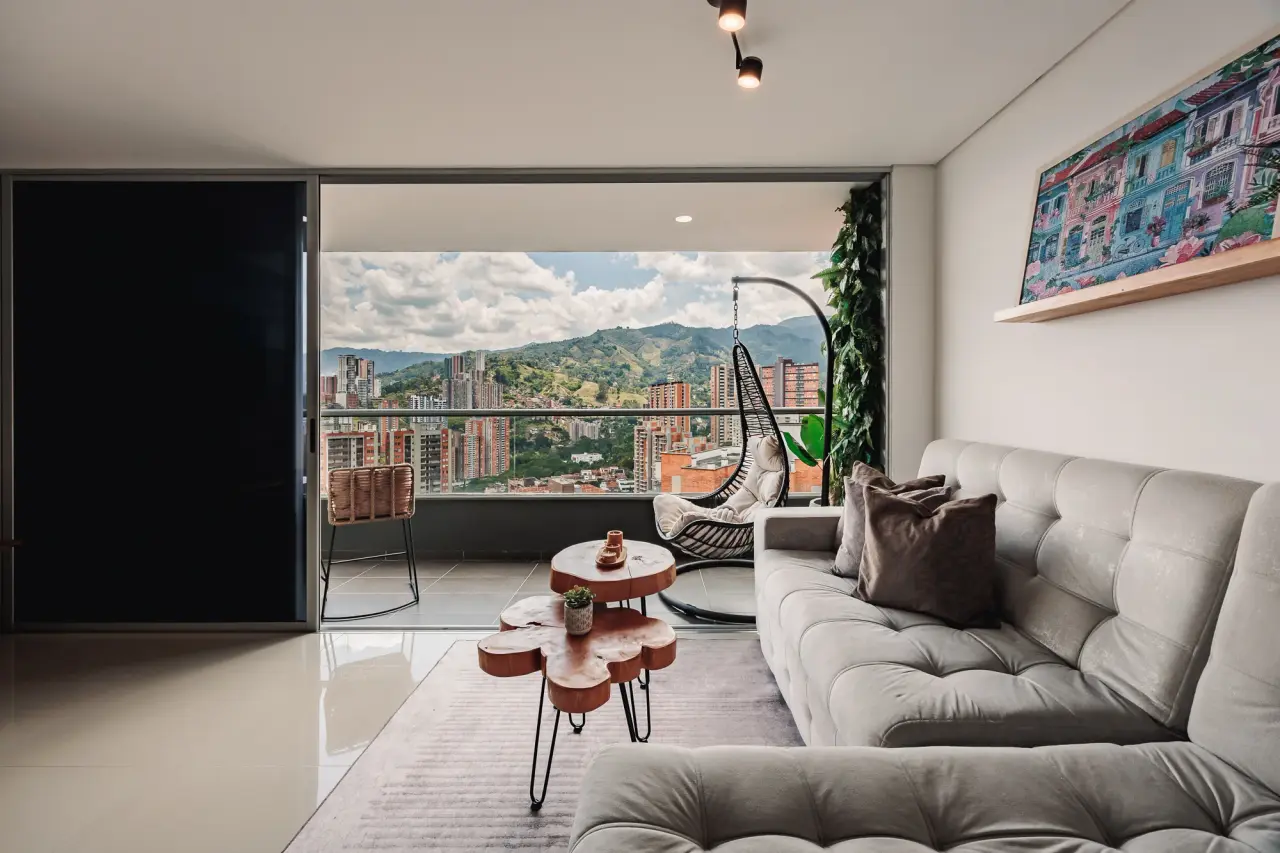 Modular sofa and the open balcony doors in the living room, mountains beyond